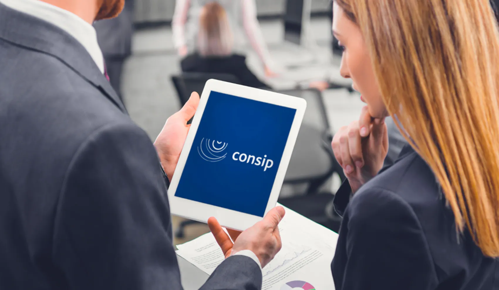 Funzionari osservano su tablet il logo Consip